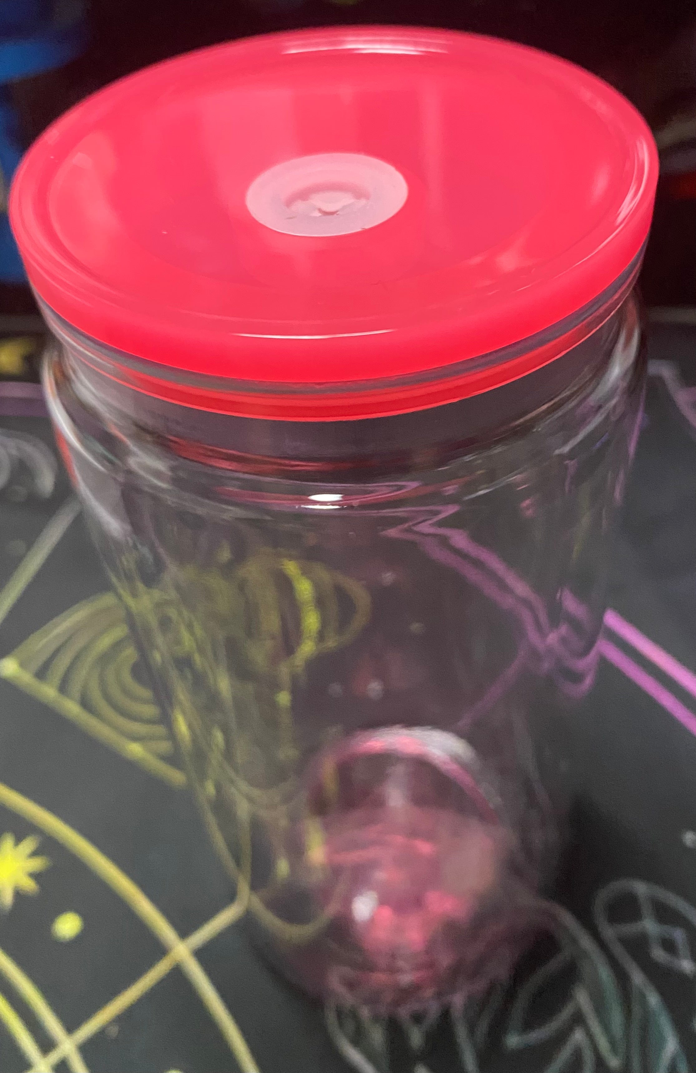 Clear container with a dark pink lid 