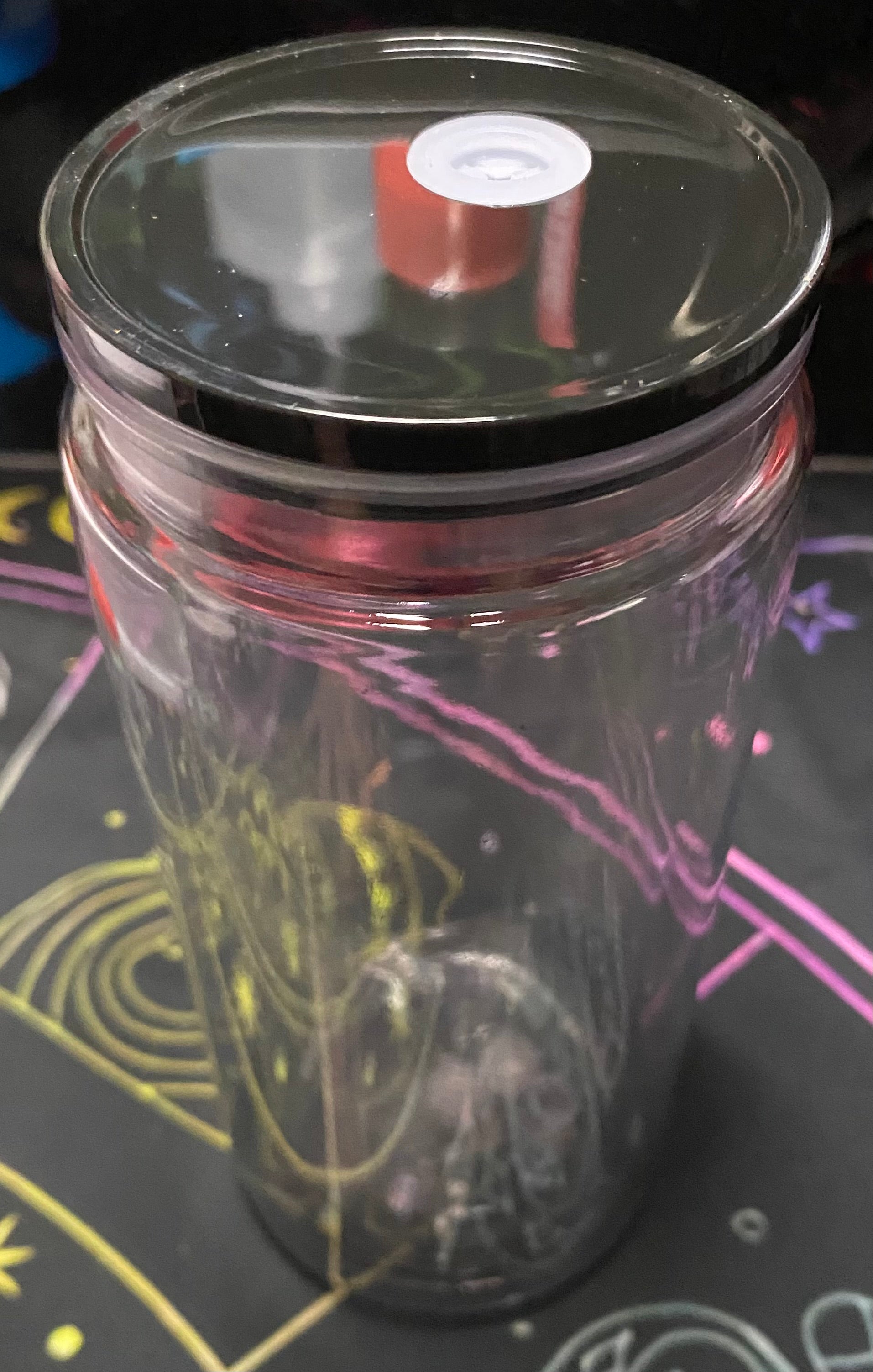 Clear glass tumbler with a black lid